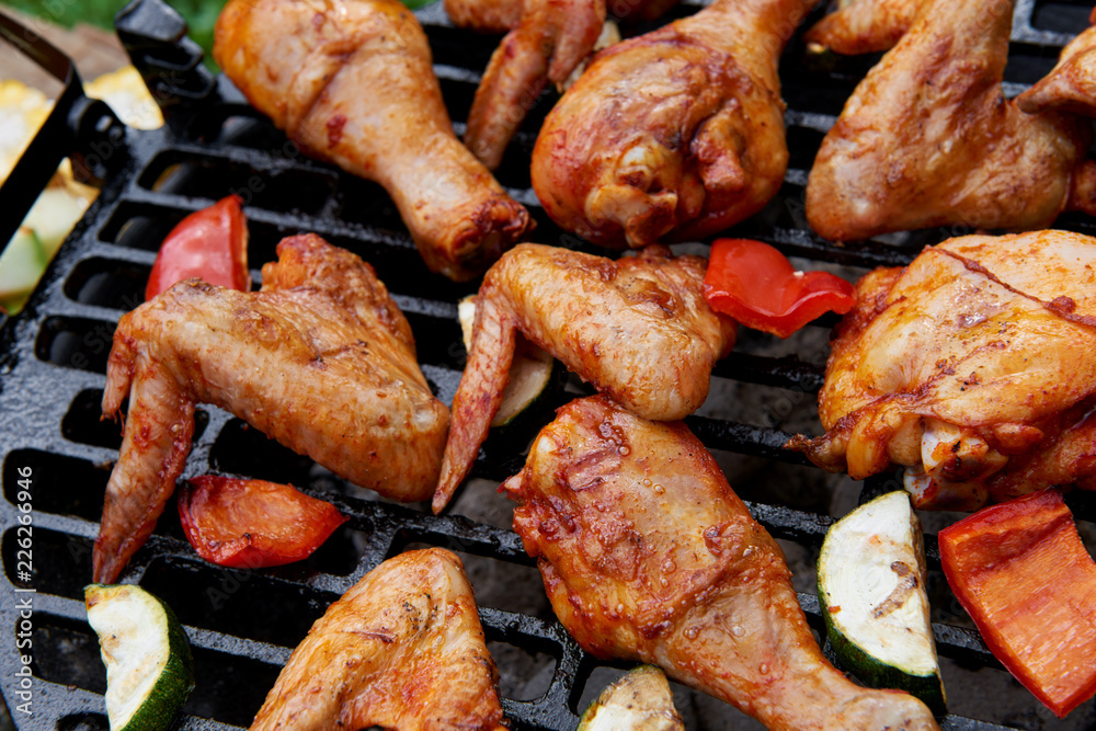 Meat and vegetables during grilling. Assorted types of chicken