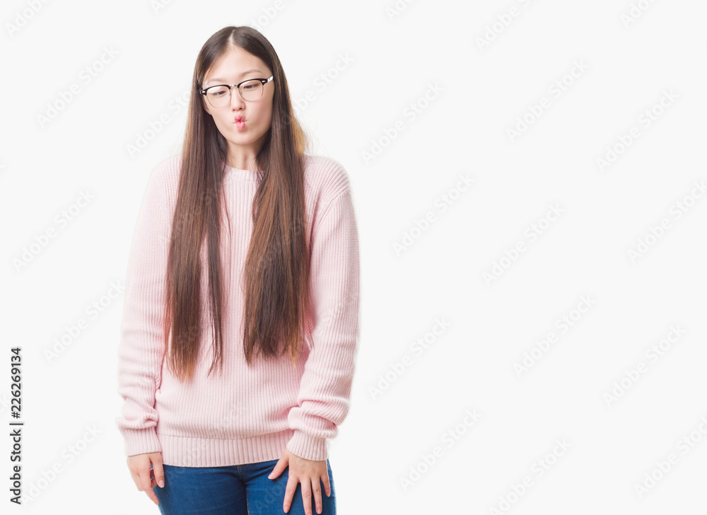Fototapeta premium Young Chinese woman over isolated background wearing glasses making fish face with lips, crazy and comical gesture. Funny expression.