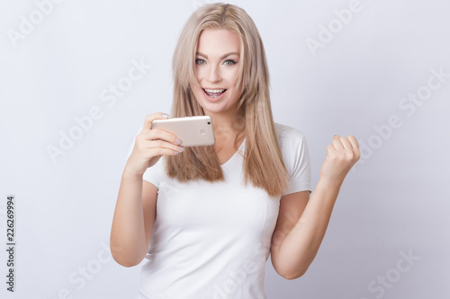 Blonde woman playing on mobile phone