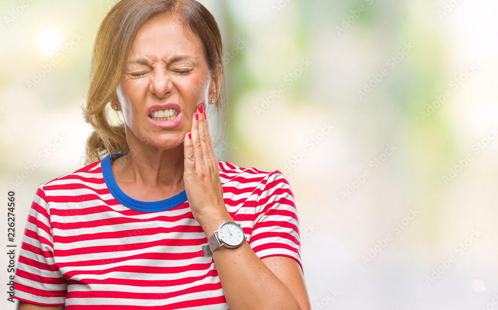 Middle age senior hispanic woman over isolated background touching mouth with hand with painful expression because of toothache or dental illness on teeth. Dentist concept. Middle age senior hispanic woman over isolated background touching mouth with hand with painful expression because of toothache or dental illness on teeth. Dentist concept.