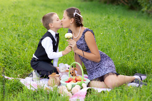 Little boy and teen age girl having picnic outdoors