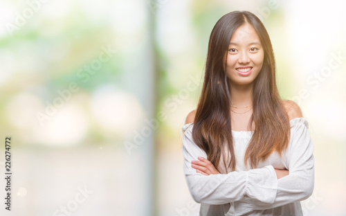 Young asian woman over isolated background happy face smiling with crossed arms looking at the camera. Positive person.