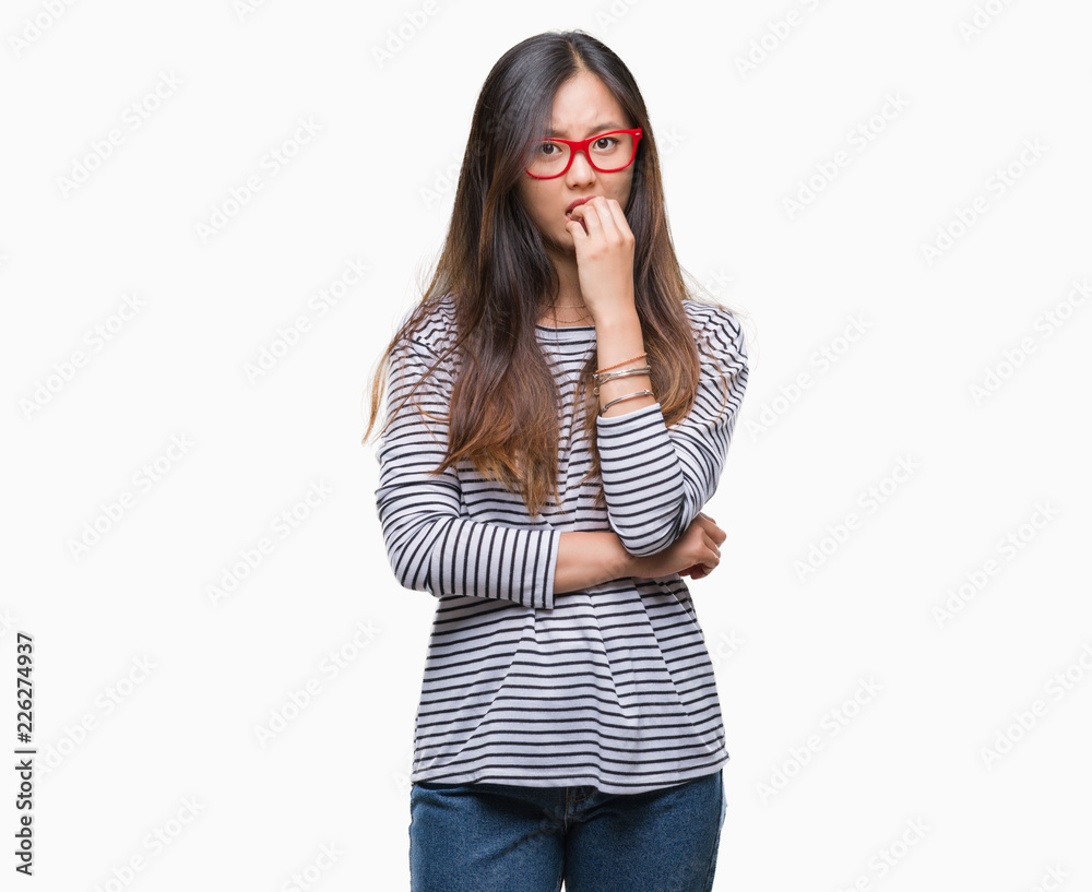Young asian woman wearing glasses over isolated background looking stressed and nervous with hands on mouth biting nails. Anxiety problem. Young asian woman wearing glasses over isolated background looking stressed and nervous with hands on mouth biting nails. Anxiety problem.