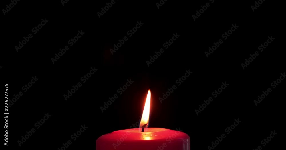 Red Christmas candle with golden light on dark background. Shot in 4k resolution Red Christmas candle with golden light on dark background. Shot in 4k resolution