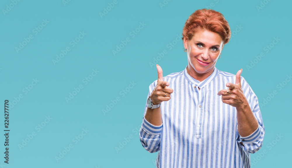 Atrractive senior caucasian redhead woman over isolated background pointing fingers to camera with happy and funny face. Good energy and vibes. Atrractive senior caucasian redhead woman over isolated background pointing fingers to camera with happy and funny face. Good energy and vibes.