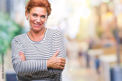 Atrractive senior caucasian redhead woman over isolated background happy face smiling with crossed arms looking at the camera. Positive person.