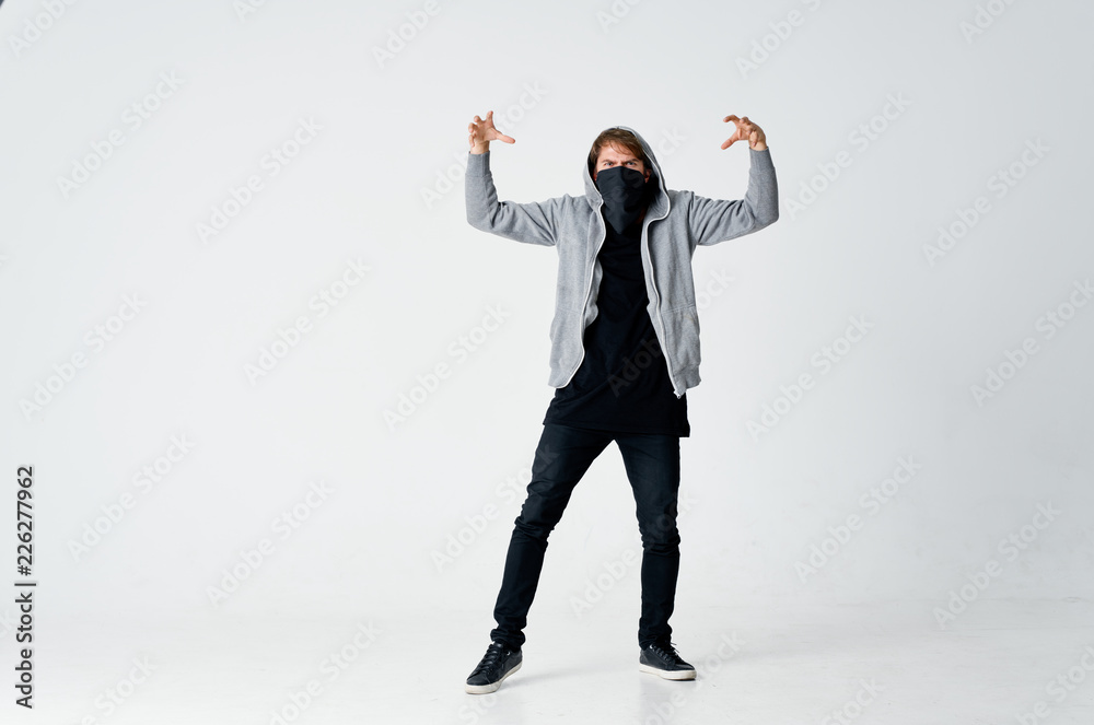 a man in black clothes a mask on his face and a gray jacket with a hood a man in black clothes a mask on his face and a gray jacket with a hood