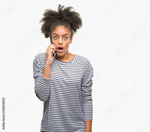 Young afro american woman talking on the phone over isolated background scared in shock with a surprise face, afraid and excited with fear expression