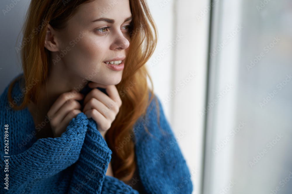 woman looks out the window on the windowsill