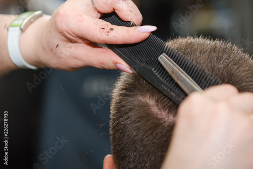Scissor the hair of a man in a barbershop