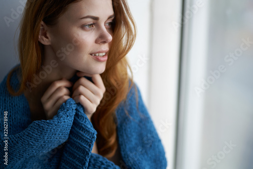 woman looks out the window on the windowsill