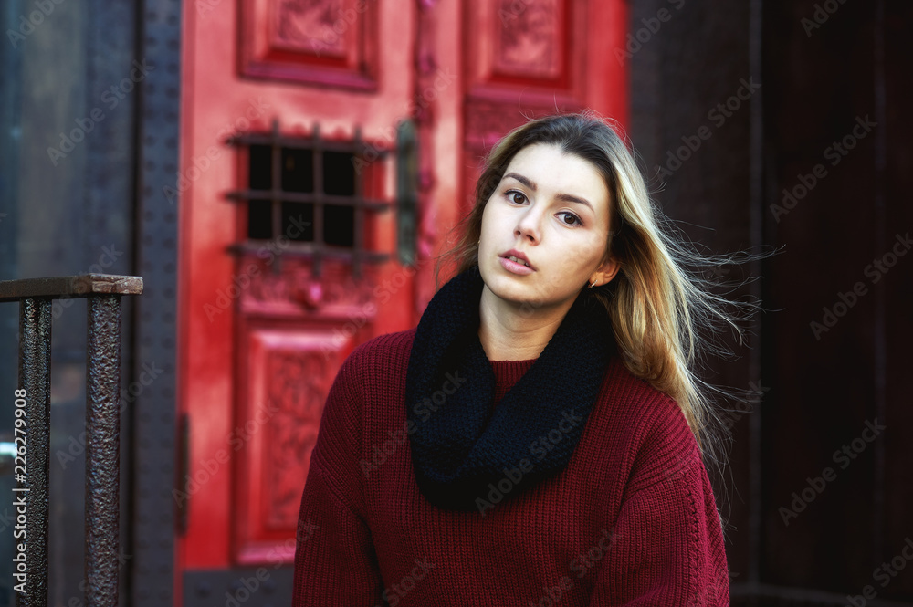 Portrait of a young girl in the autumn city . The girl in warm and comfortable clothes Portrait of a young girl in the autumn city . The girl in warm and comfortable clothes