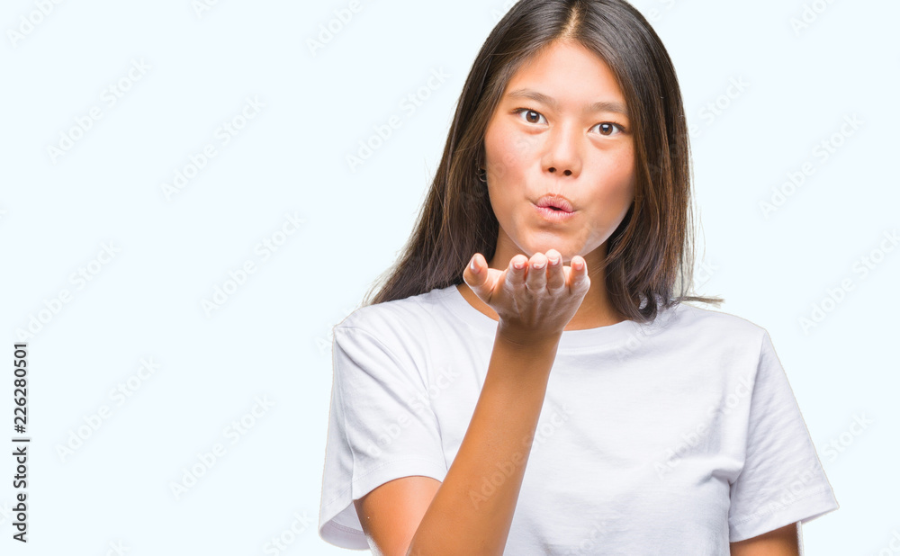 Young asian woman over isolated background looking at the camera blowing a kiss with hand on air being lovely and sexy. Love expression. Young asian woman over isolated background looking at the camera blowing a kiss with hand on air being lovely and sexy. Love expression.