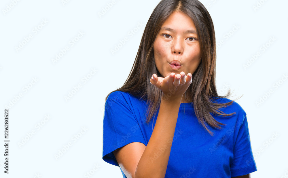 Young asian woman over isolated background looking at the camera blowing a kiss with hand on air being lovely and sexy. Love expression. Young asian woman over isolated background looking at the camera blowing a kiss with hand on air being lovely and sexy. Love expression.