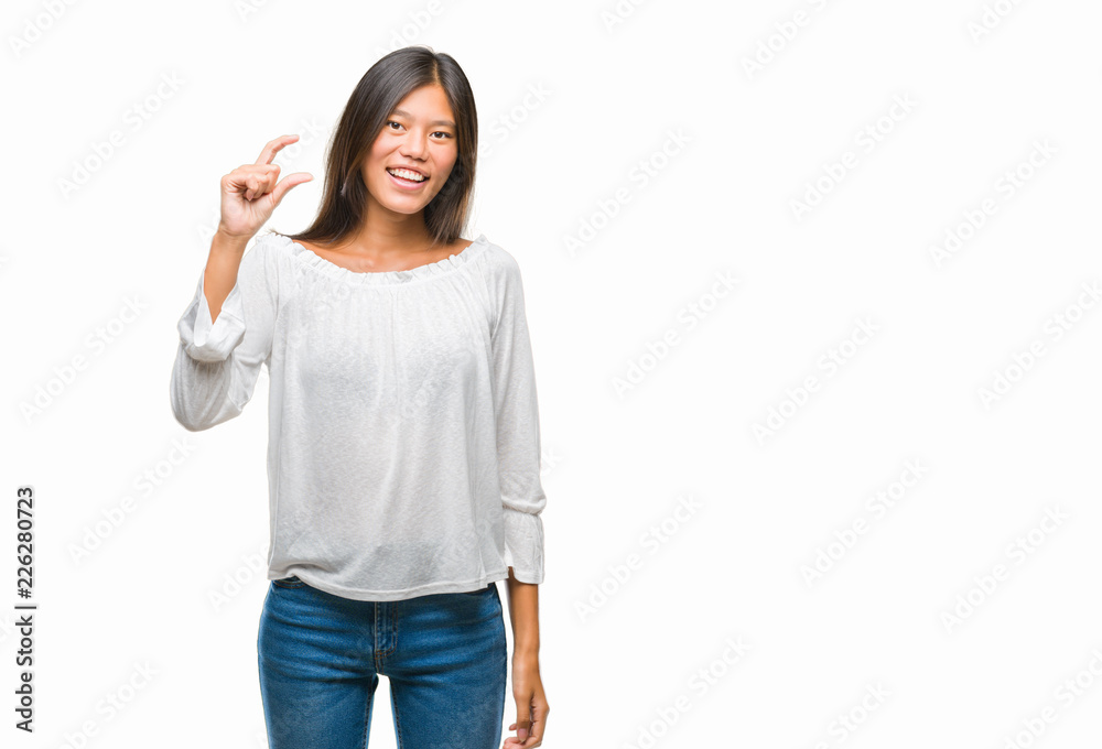 Young asian woman over isolated background smiling and confident gesturing with hand doing size sign with fingers while looking and the camera. Measure concept. Young asian woman over isolated background smiling and confident gesturing with hand doing size sign with fingers while looking and the camera. Measure concept.