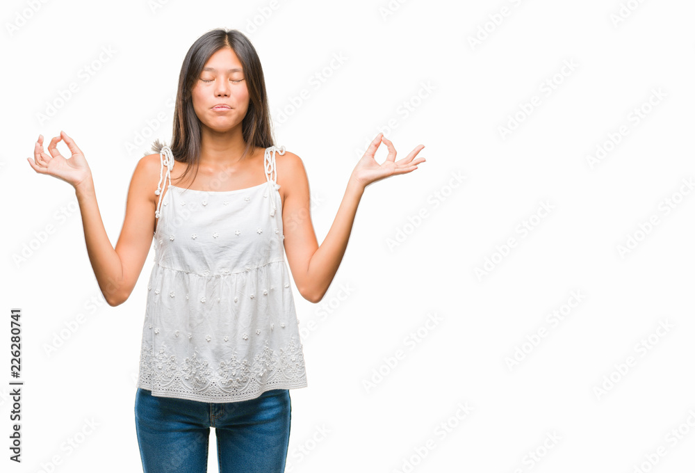 Young asian woman over isolated background relax and smiling with eyes closed doing meditation gesture with fingers. Yoga concept. Young asian woman over isolated background relax and smiling with eyes closed doing meditation gesture with fingers. Yoga concept.