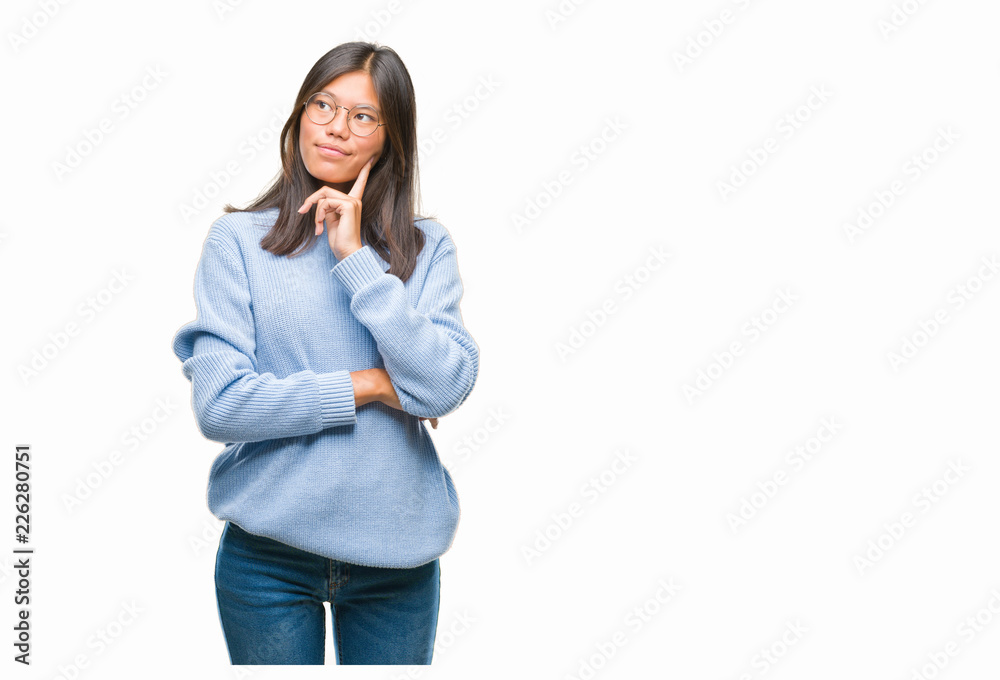Young asian woman wearing winter sweater over isolated background with hand on chin thinking about question, pensive expression. Smiling with thoughtful face. Doubt concept. Young asian woman wearing winter sweater over isolated background with hand on chin thinking about question, pensive expression. Smiling with thoughtful face. Doubt concept.