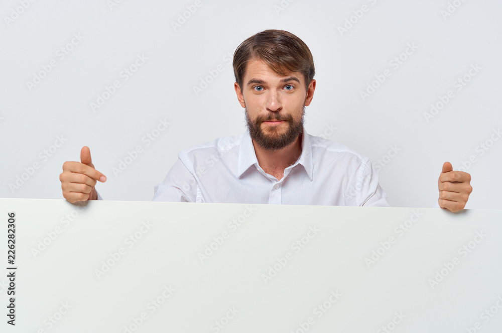 a man in a shirt is standing behind a white drawing paper a man in a shirt is standing behind a white drawing paper