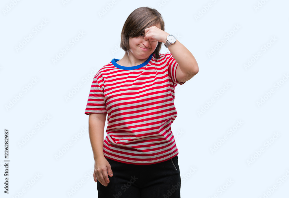 Young adult woman with down syndrome over isolated background tired rubbing nose and eyes feeling fatigue and headache. Stress and frustration concept. Young adult woman with down syndrome over isolated background tired rubbing nose and eyes feeling fatigue and headache. Stress and frustration concept.
