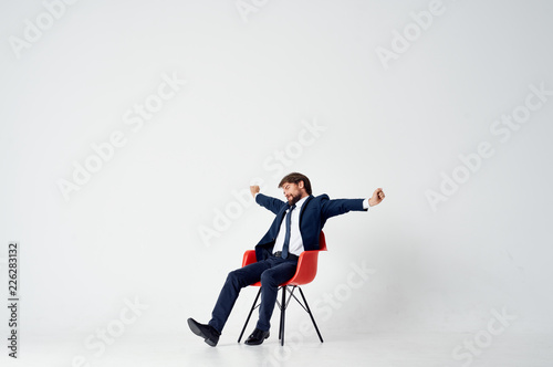 a man in a suit is stretched while sitting on a chair © SHOTPRIME STUDIO