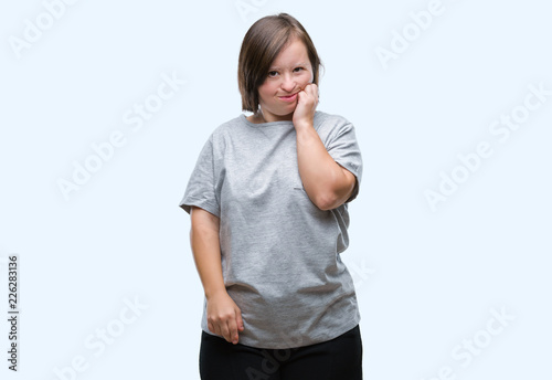 Young adult woman with down syndrome over isolated background touching mouth with hand with painful expression because of toothache or dental illness on teeth. Dentist concept.