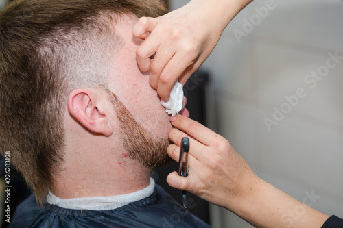Shave a man's beard with a straight razor