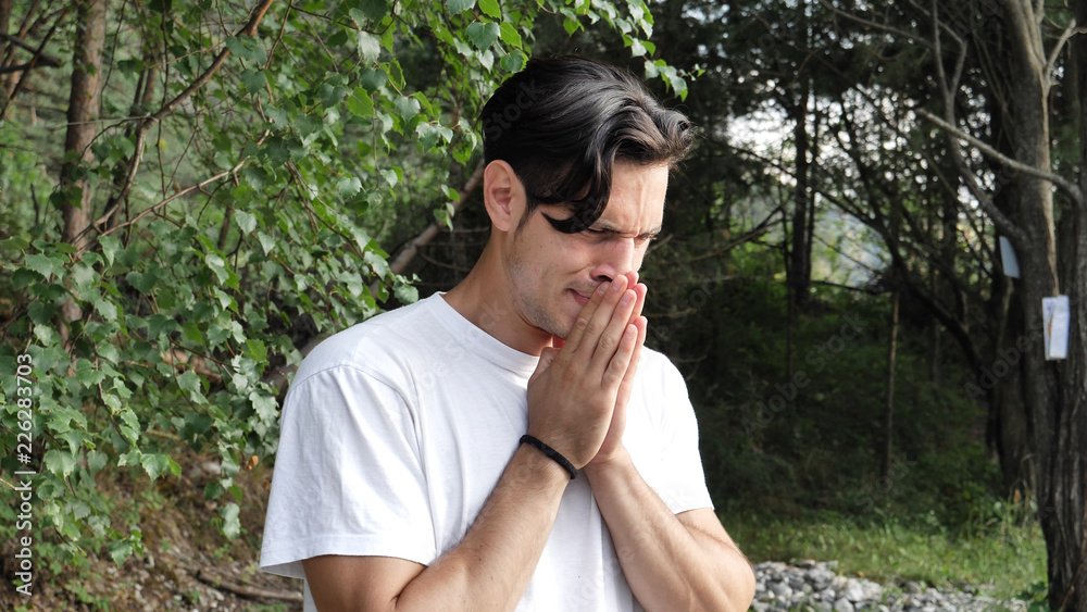 Young handsome man standing in nature, sad, worried or upset, crying Young handsome man standing in nature, sad, worried or upset, crying