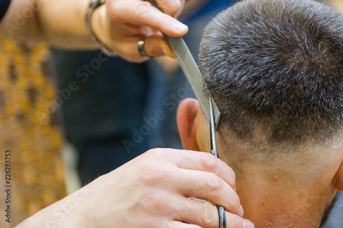 Scissor the hair of a man in a barbershop