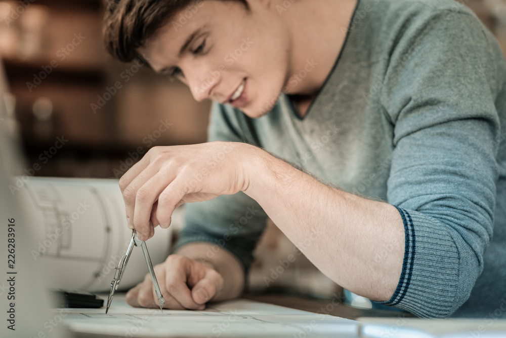 Professional drawing. Selective focus of a professional drawing tool being in hands of a positive nice smart student Professional drawing. Selective focus of a professional drawing tool being in hands of a positive nice smart student