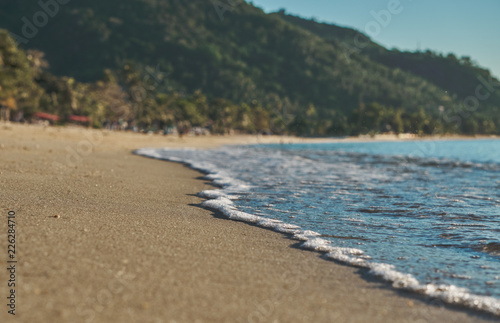  Sea surf on the sandy beach on a sunny morning