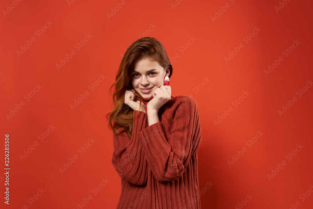 woman in sweater holds her hands near herself on the red background woman in sweater holds her hands near herself on the red background