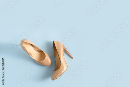 Beige women high heel shoes on pink background. Fashion blog look. Top view, free copy space.