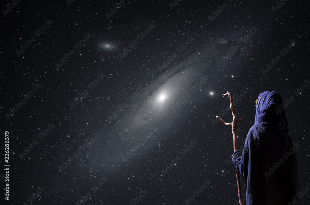 eine mystische Person beobachtet nachts den Sternenhimmel mit der Andromedagalaxie