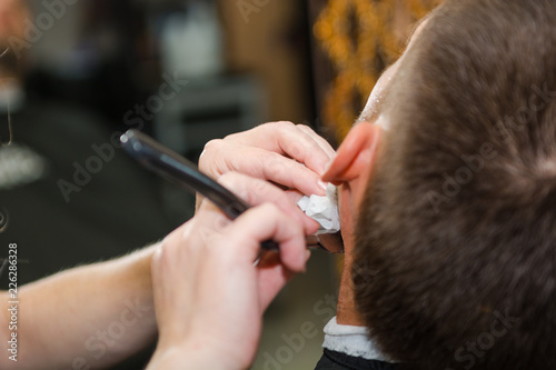 Shave a man's beard with a straight razor