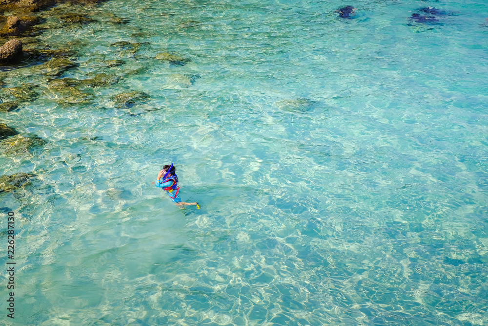 Snorkeling in crystal clear water in Perhentian Island.