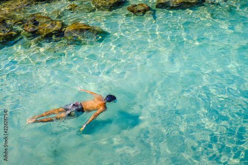 Snorkeling in crystal clear water in Perhentian Island.