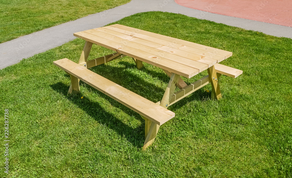 Recreation area with picnic table on green lawn in a park