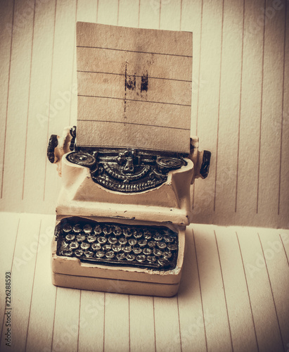 Retro syled tiny typewriter model on paper photo