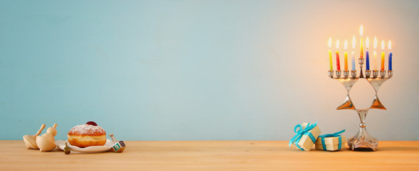 Banner of jewish holiday Hanukkah background with traditional spinnig top, menorah (traditional candelabra) and burning candles