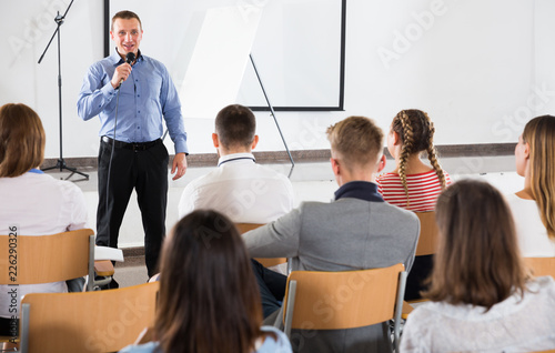 Male professor delivering speech to students