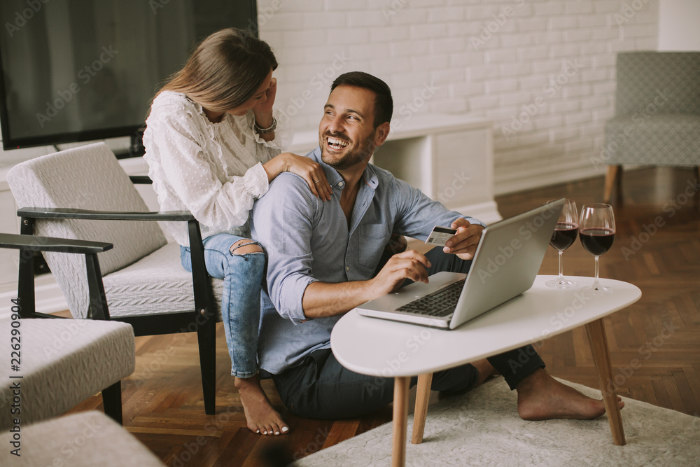 Cheerful couple searching internet and shopping online Cheerful couple searching internet and shopping online