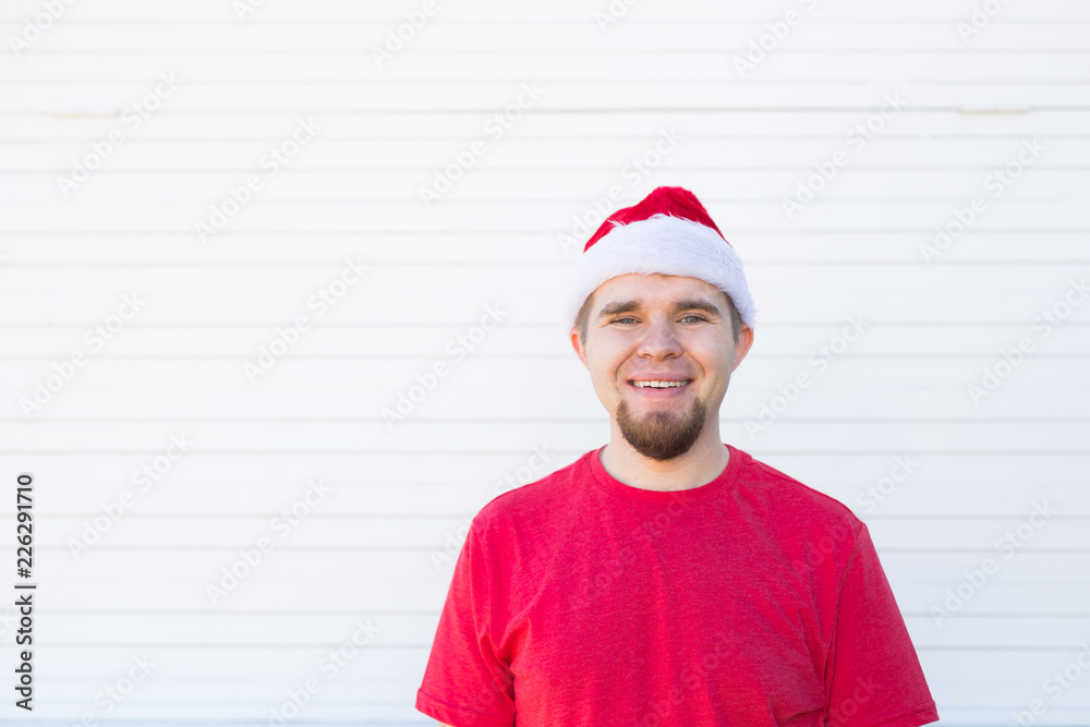 Holidays, christmas and people concept - portrait of funny handsome man in santa hat have fun on white background with copy space Holidays, christmas and people concept - portrait of funny handsome man in santa hat have fun on white background with copy space