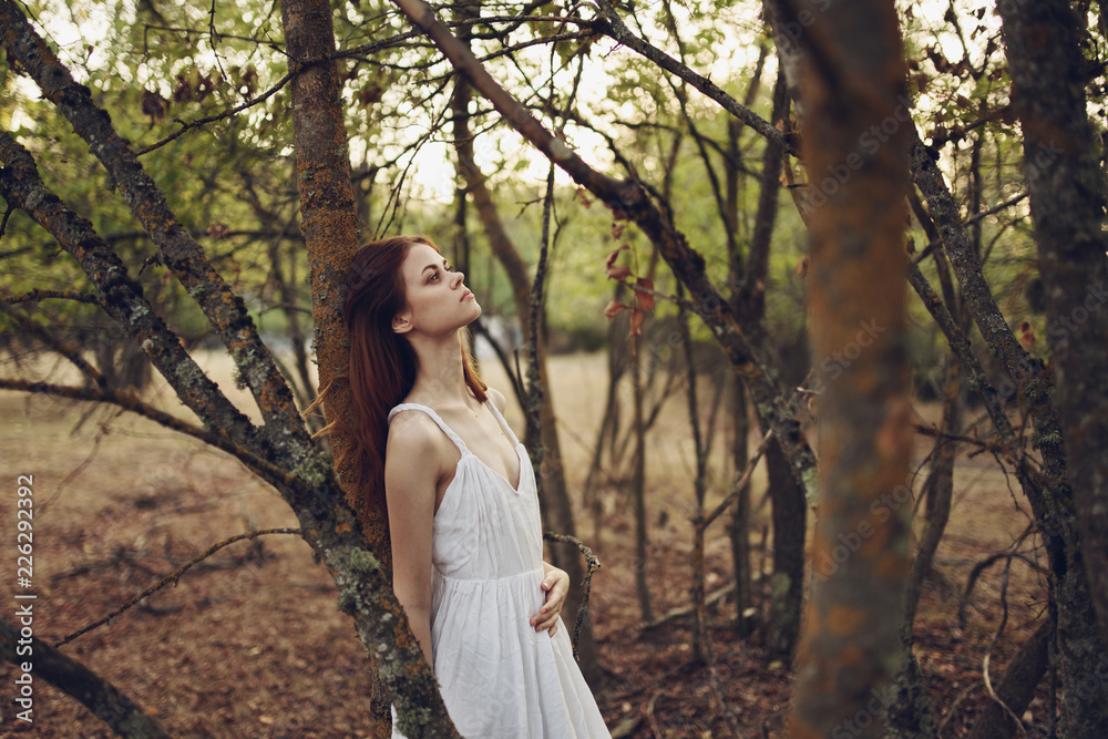 woman in the forest leaned on a tree