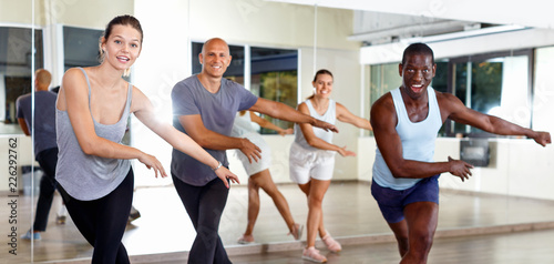 Cheerful people practicing vigorous lindy hop movements in dance class