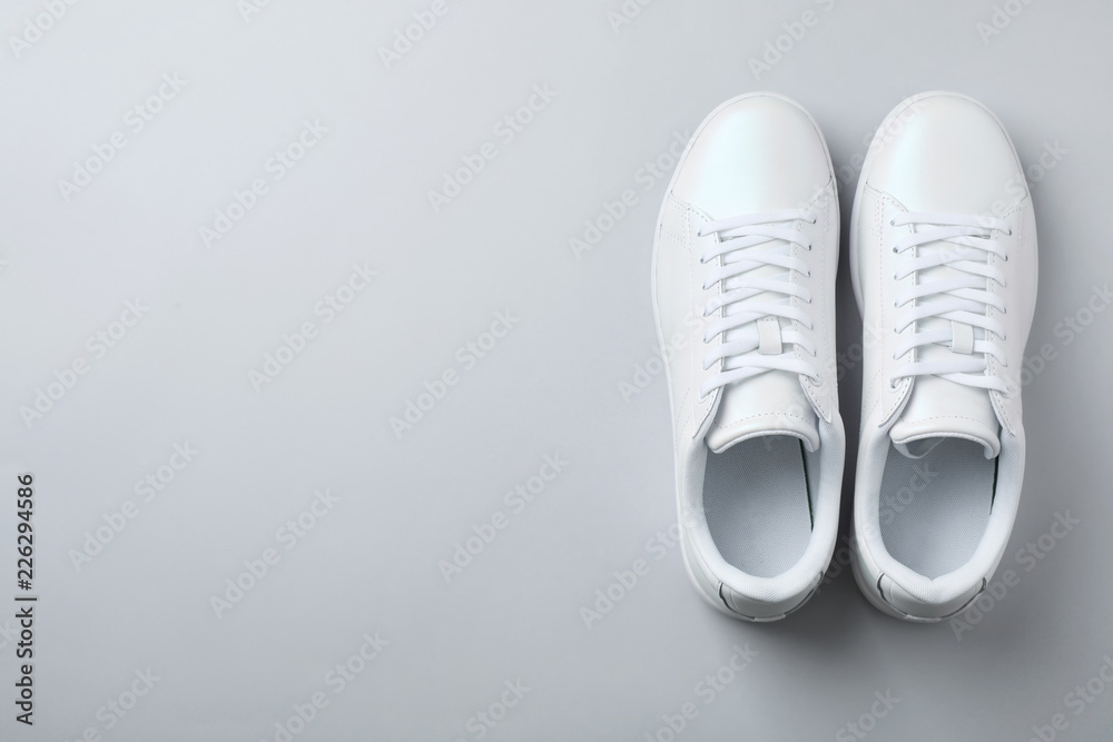 Pair of trendy sneakers on light background, flat lay. Space for text Pair of trendy sneakers on light background, flat lay. Space for text