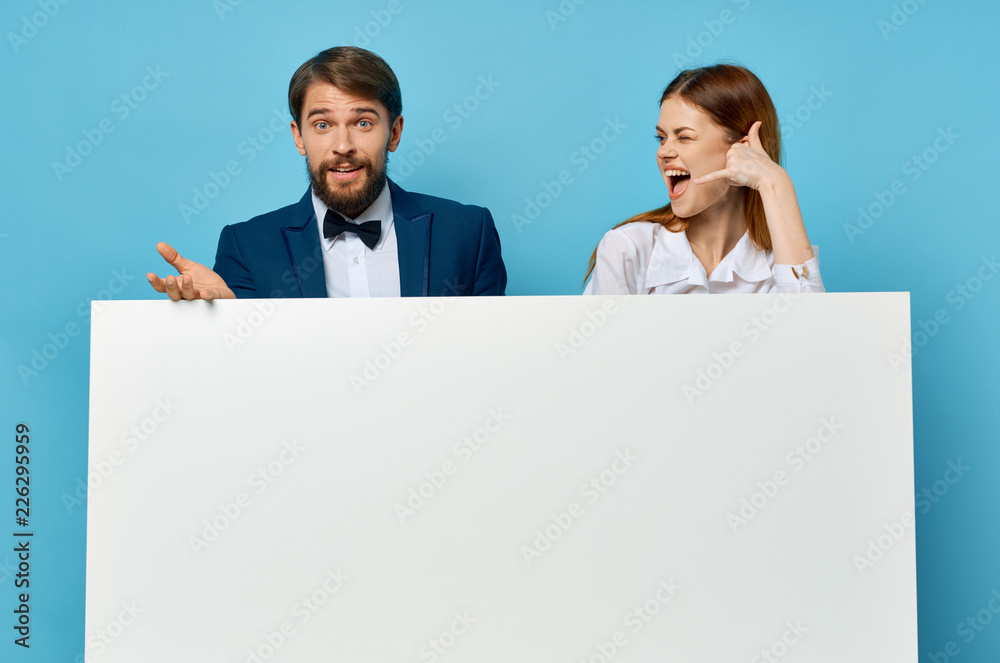 man and woman stand behind big white mockup man and woman stand behind big white mockup