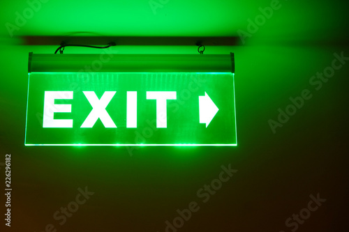 Front face raised view of green emergency fire exit sign hanging on the ceiling