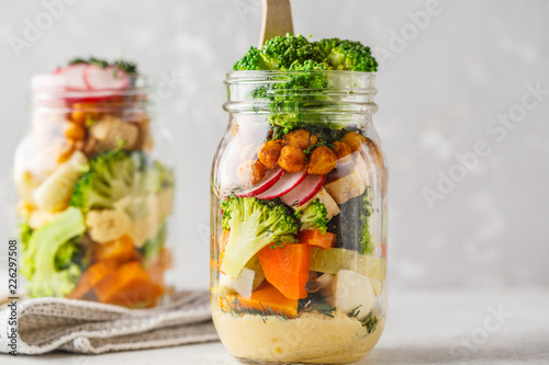 Healthy Homemade Mason Jar Salad with baked vegetables, hummus, tofu and chickpeas.