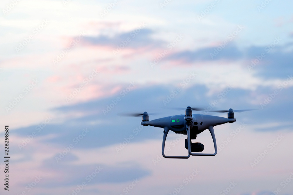 Unmanned aerial vehicle in the sky with clouds. Morning or evening flight quadcopter. Aerial video footage. Copy space. Unmanned aerial vehicle in the sky with clouds. Morning or evening flight quadcopter. Aerial video footage. Copy space.