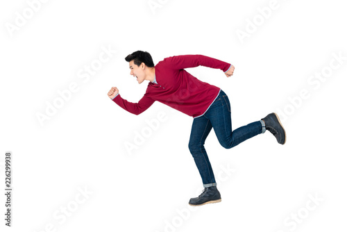 Young energetic Asian man in casual clothes running on white background